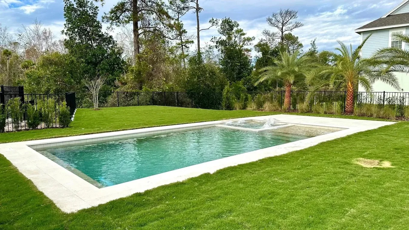 Modern rectangular concrete pool in Daytona Beach backyard with surrounding deck space designed for future screen enclosure installation