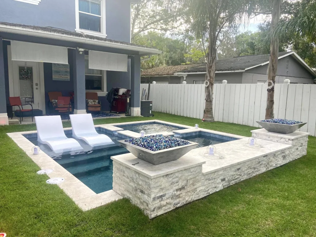 Modern backyard pool layout with tanning ledge, integrated spa, and patio design for a small Florida backyard.