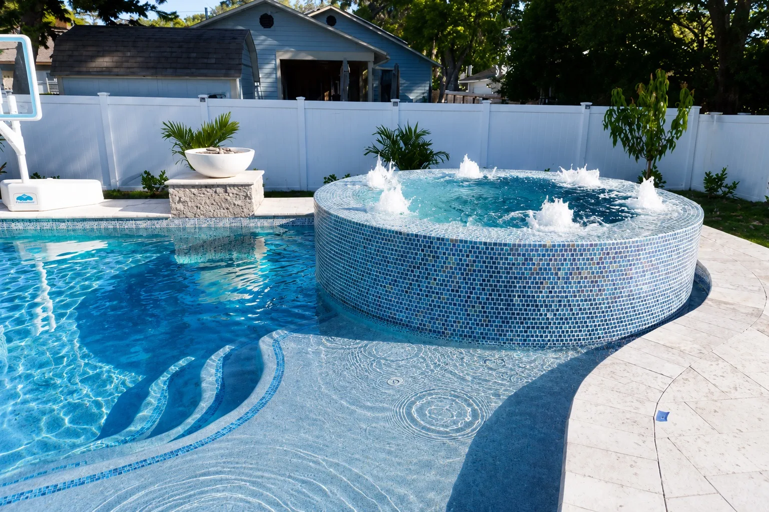 Custom swimming pool with an elevated attached spa and premium tile finish in Orlando, illustrating a pool and spa combination design.
